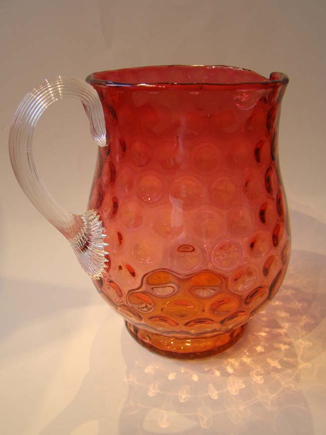 An attractive vintage cranberry glass 'thumbprint' pattern pitcher